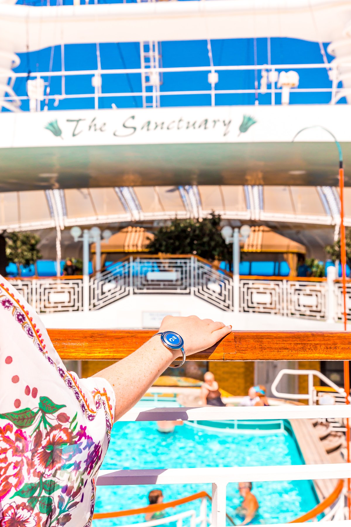 Woman's hand resting on a railing on a cruise ship.