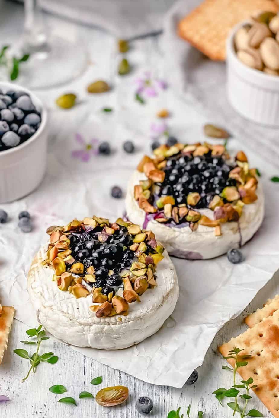Easiest baked camembert recipe EVER! Camembert cheese topped with thyme sprigs, honey, blueberries and baked until melty perfection. Delicious! The Yummy Bowl