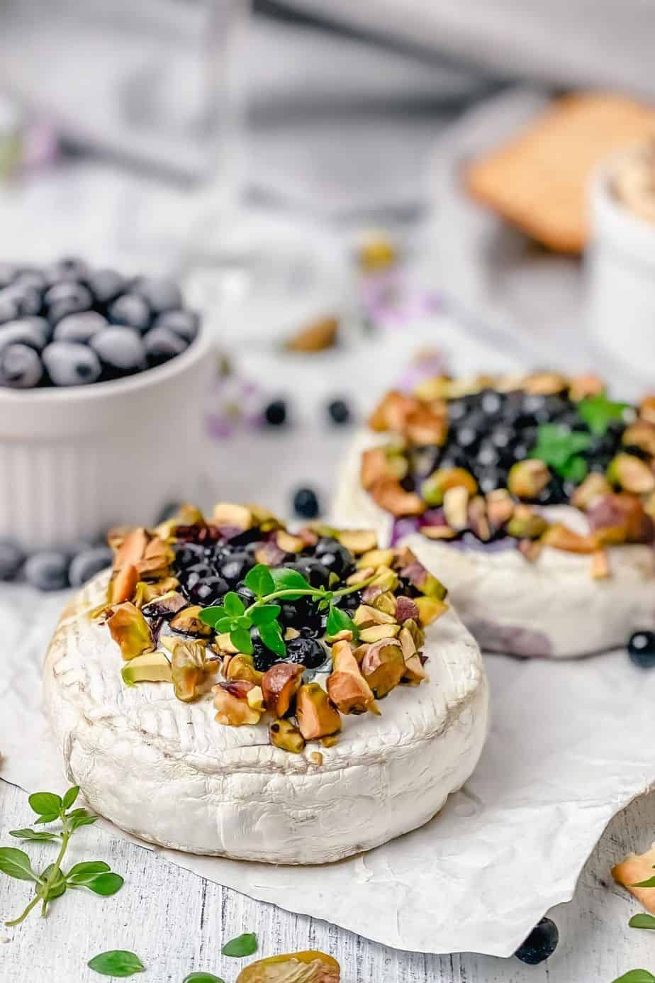 Easiest baked camembert recipe EVER! Camembert cheese topped with thyme sprigs, honey, blueberries and baked until melty perfection. Delicious! The Yummy Bowl