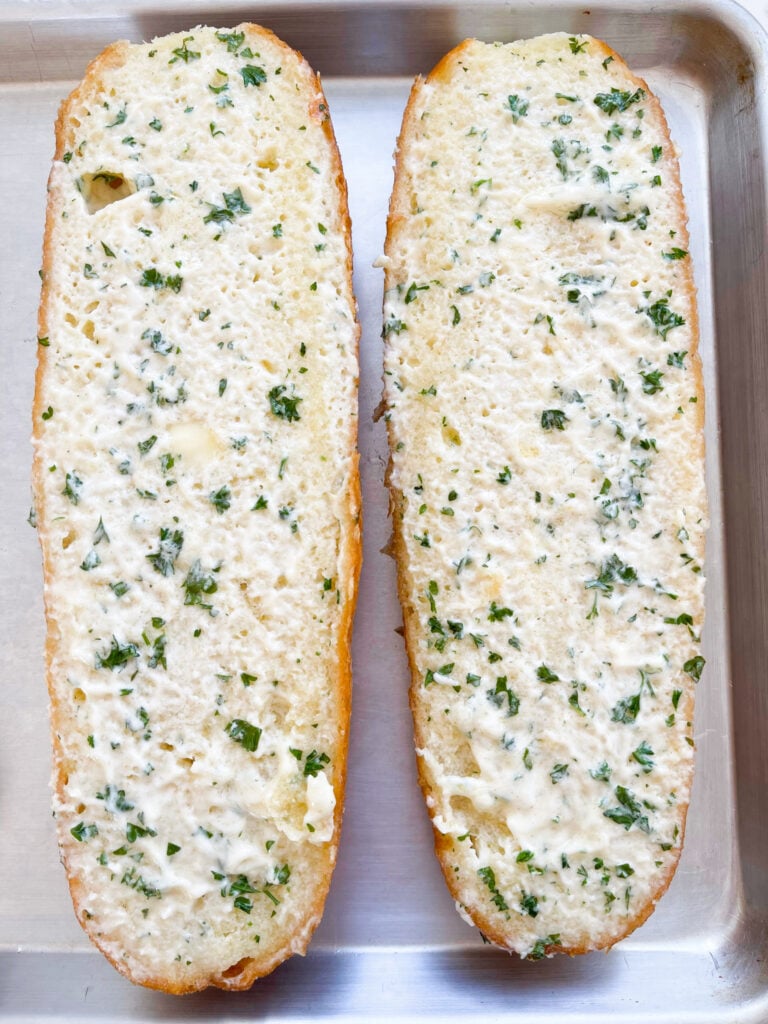 garlic topping spread on top of two halves of french bread 