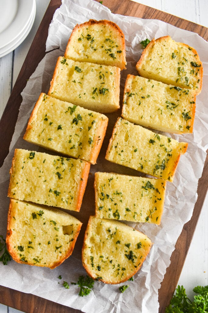 two baked garlic bread loaves cut into pieces 