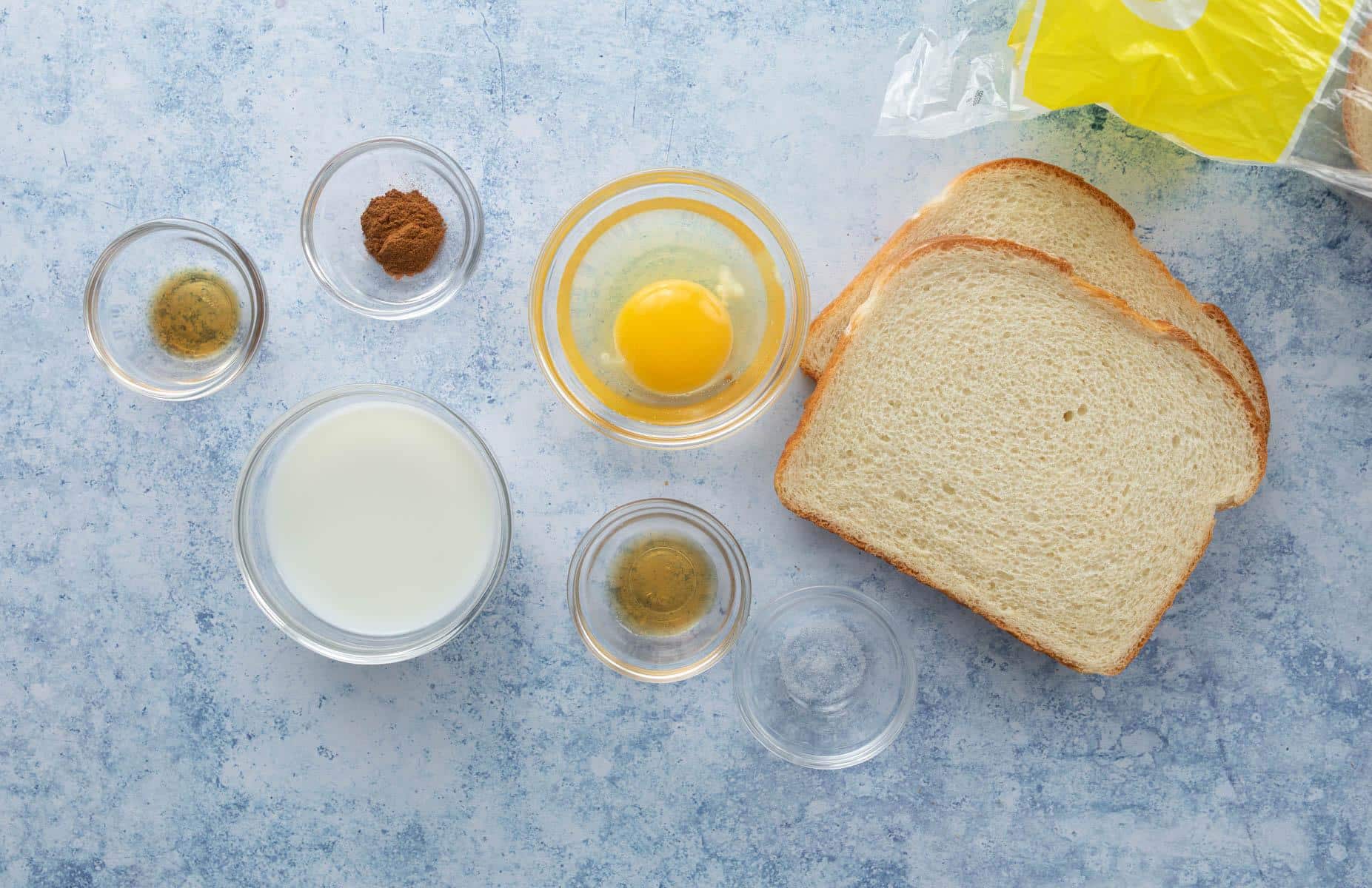 bread, milk, egg, seasonings on blue table