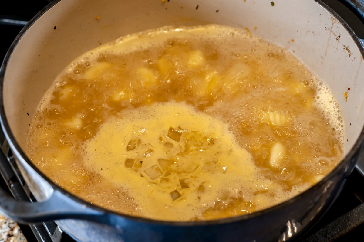 broth with gnocchi simmering in dutch oven.