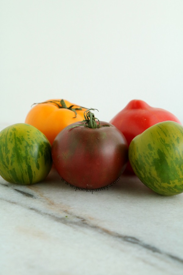 5 heirloom tomatoes on marble board