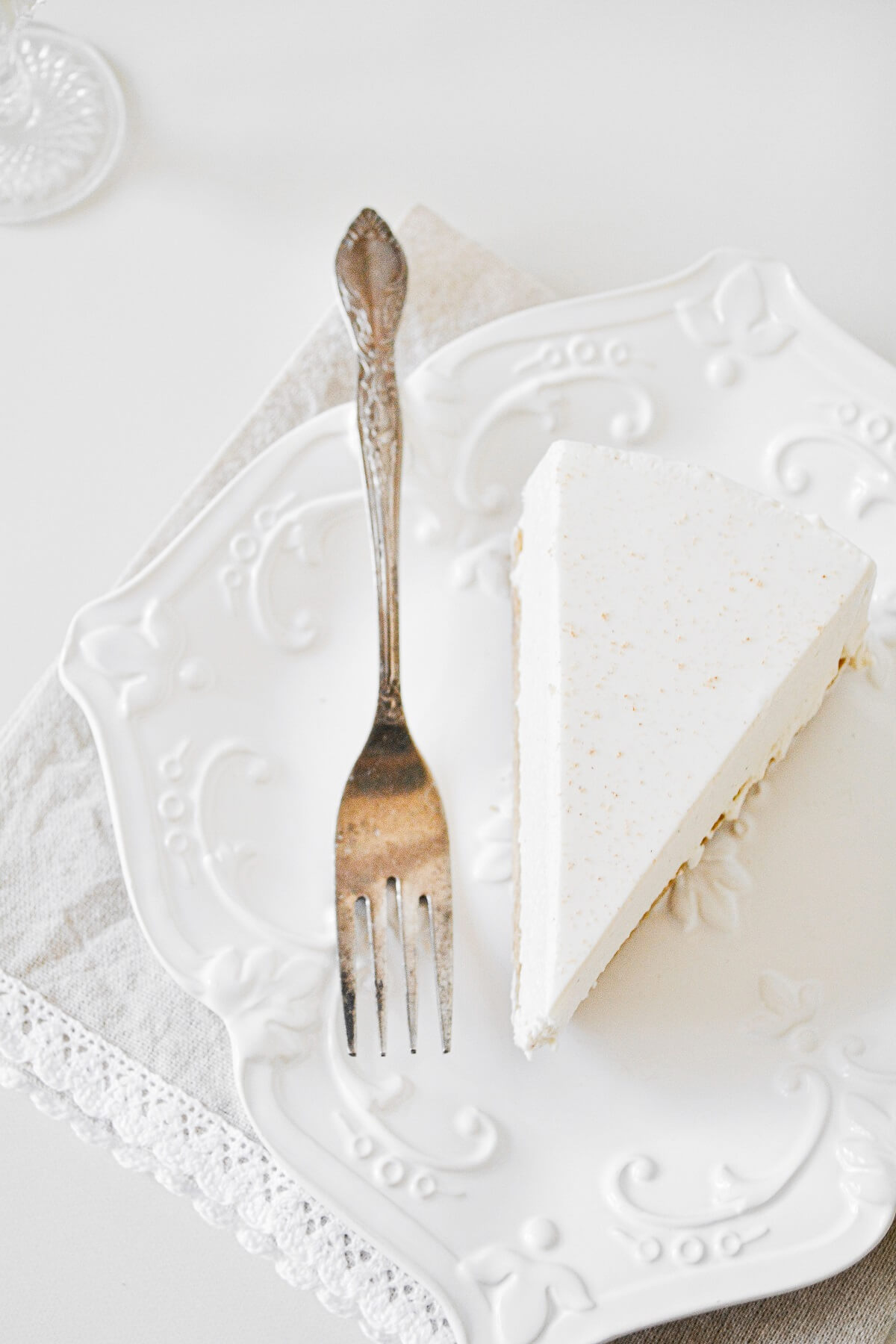 A piece of eggnog cheesecake on a white plate.