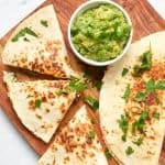 cooked breakfast quesadillas with bacon and spinach served with avocado