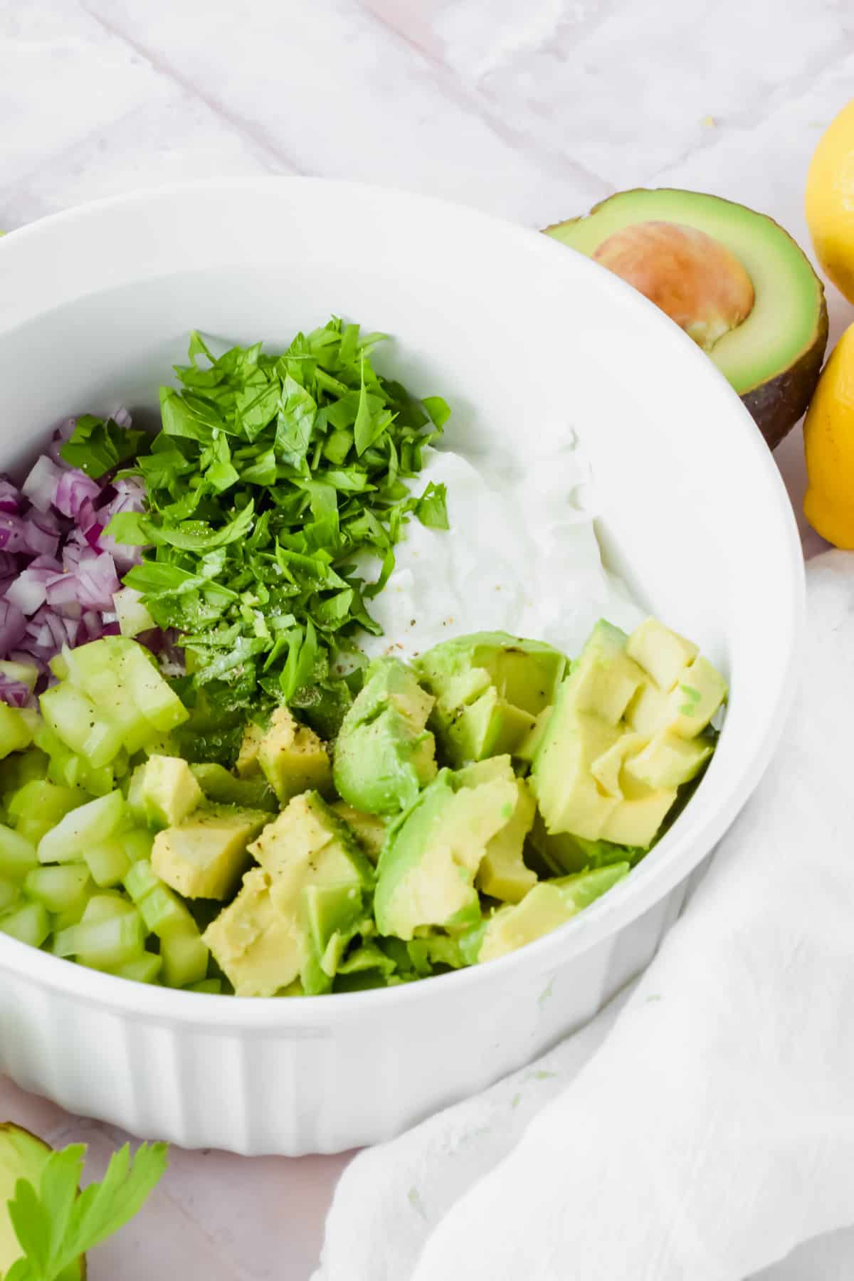 Ingredients for avocado greek yogurt chicken salad in a bowl before being mixed up 
