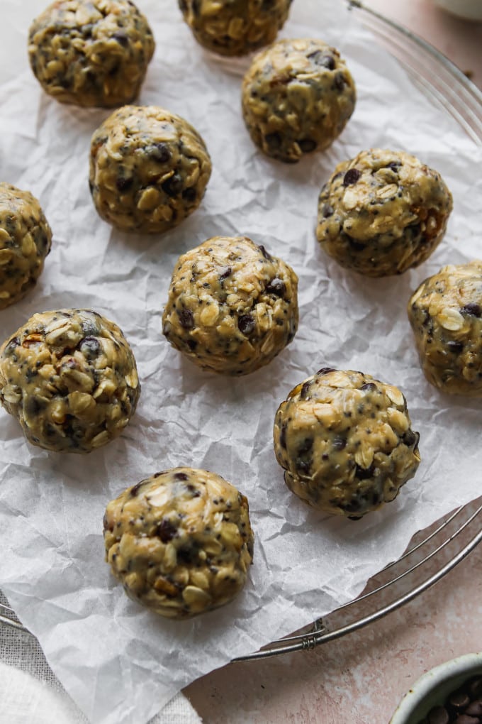 Honey tahini energy balls on a parchment-lined cooking rack.