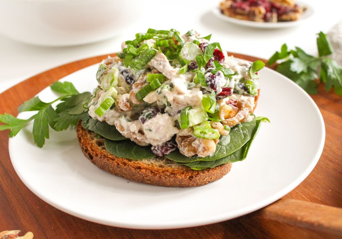 cranberry chicken salad with walnuts on a slice of bread