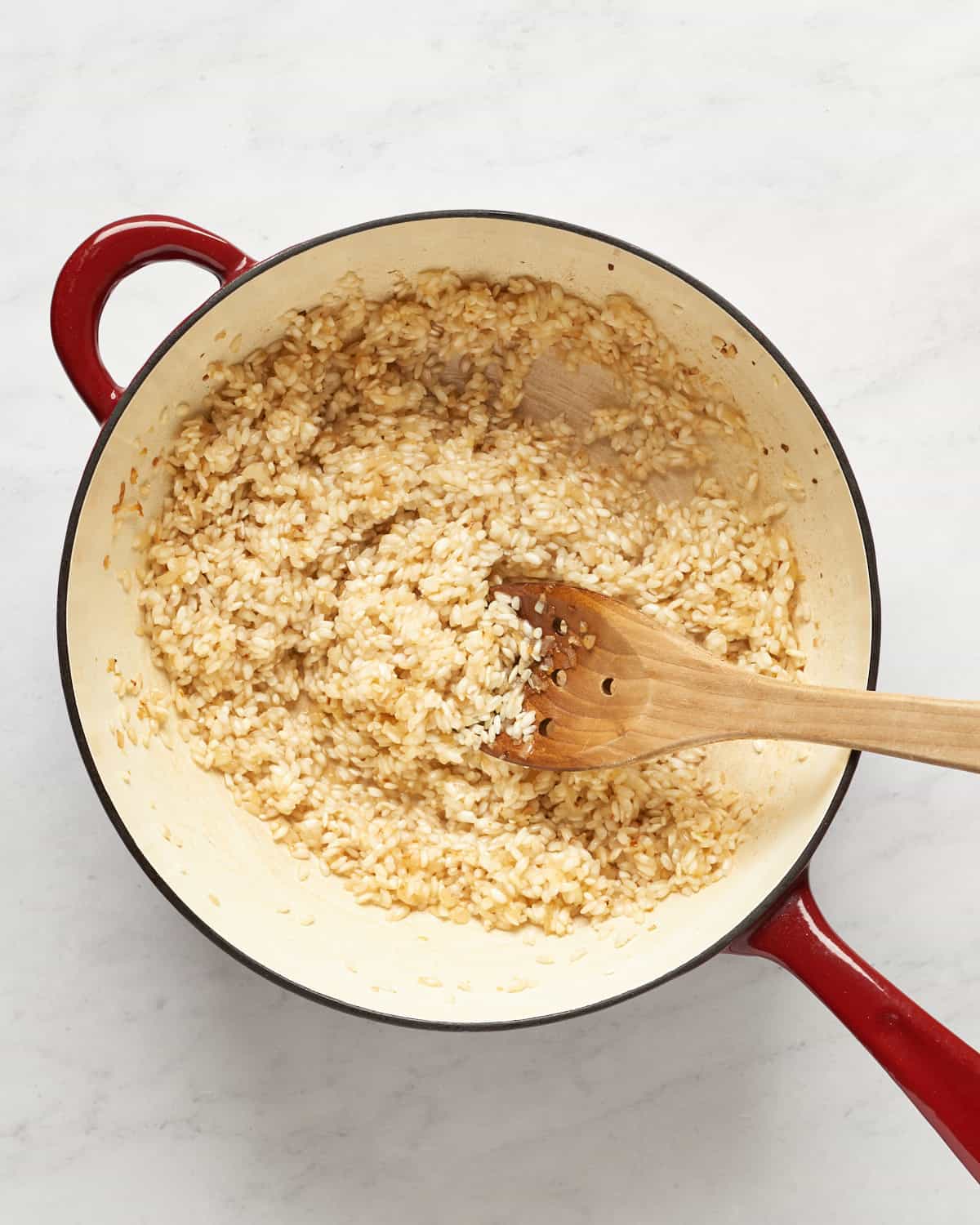 Arborio rice in saucepan with white wine, shallots, and olive oil.