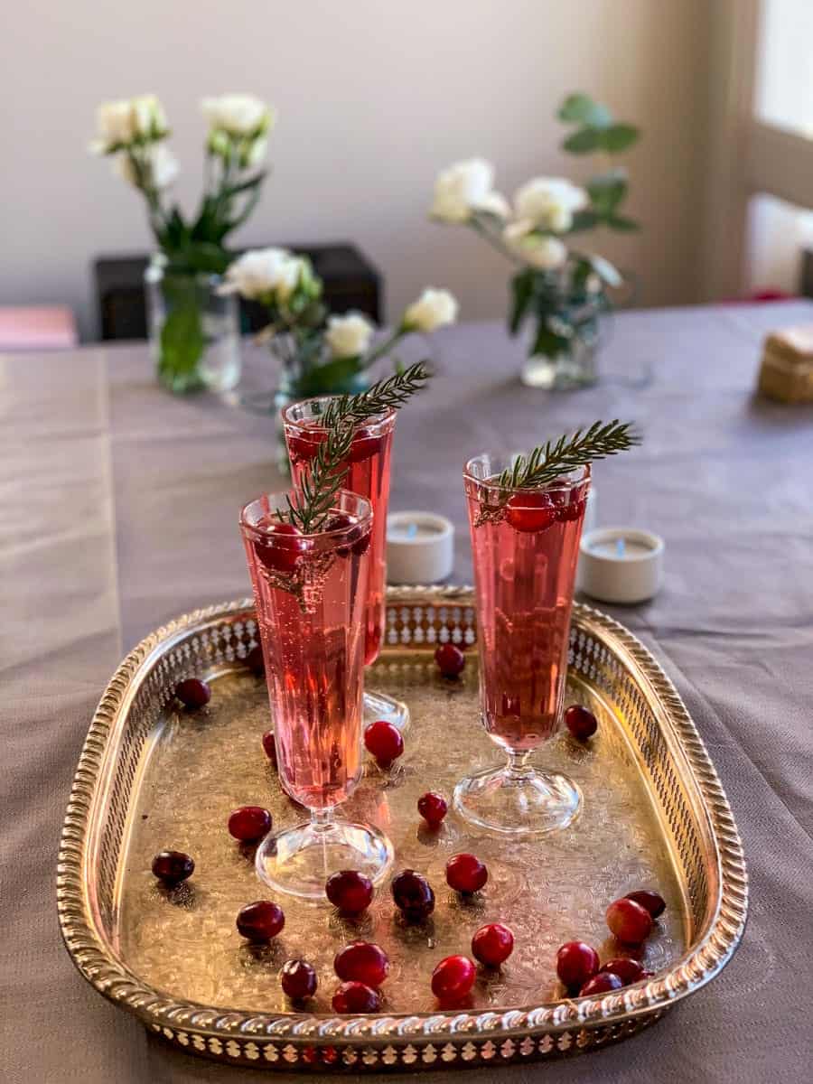 3 glasses of cranberry champagne cocktail and fresh cranberries