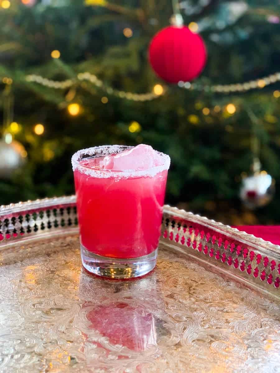 sober santa christmas punch in a glass on a silver platter in front of a decorated christmas tree