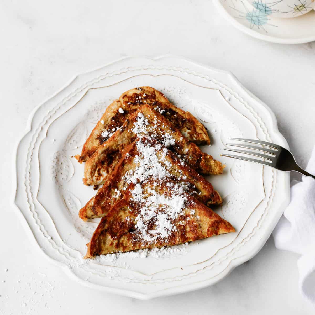 French toast dusted with powdered sugar on plate.