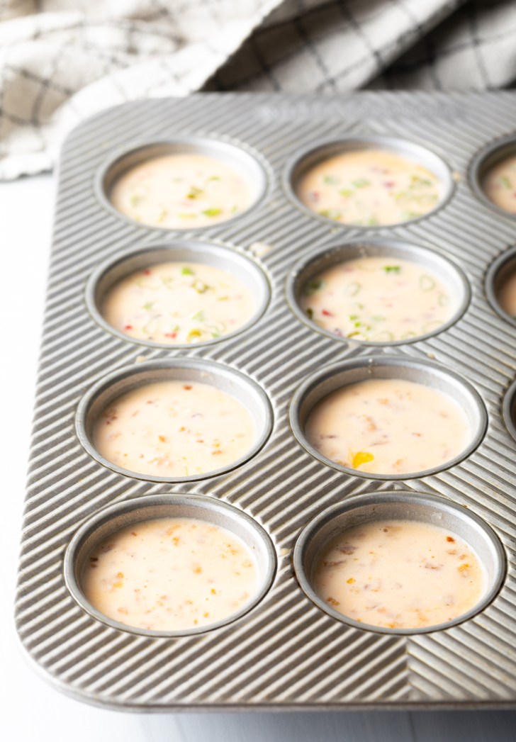 Metal muffin tin with raw egg blend.