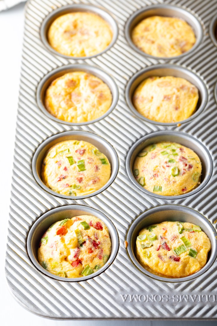 Metal muffin tin with baked egg bites.