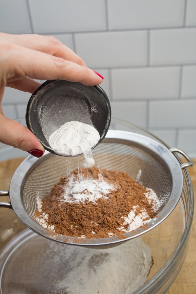 Adding baking powder to dry ingredients in a sifter.
