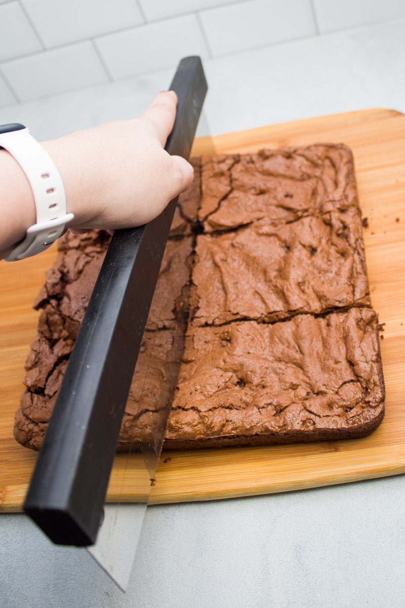 Slicing espresso chocolate chip brownies to serve.