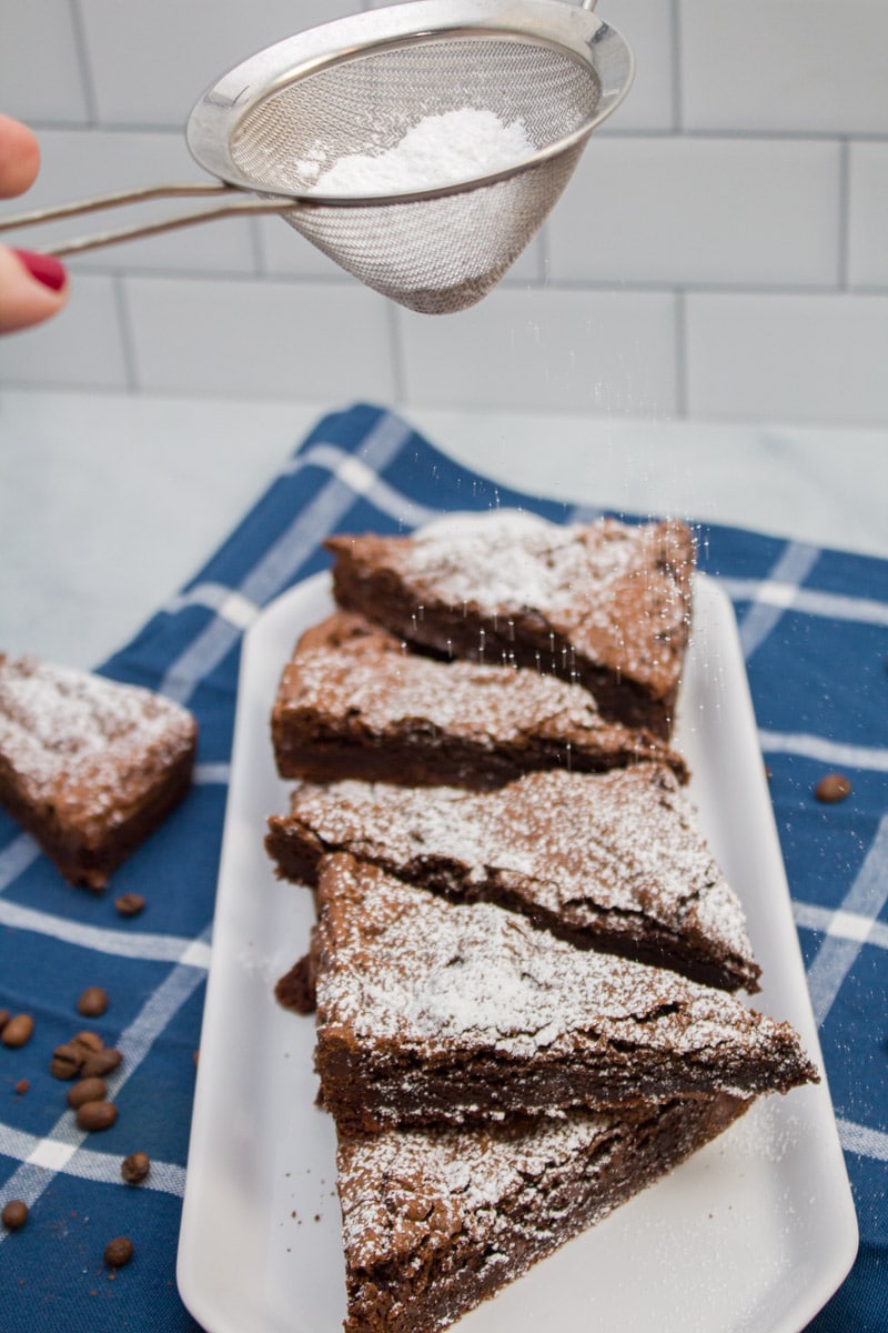 Dusting espresso chocolate chip brownies with powdered sugar.