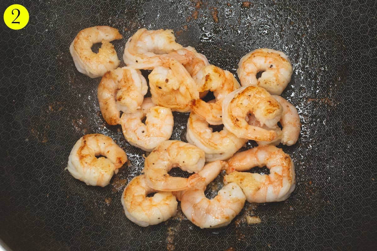 Searing the shrimp in a wok. 