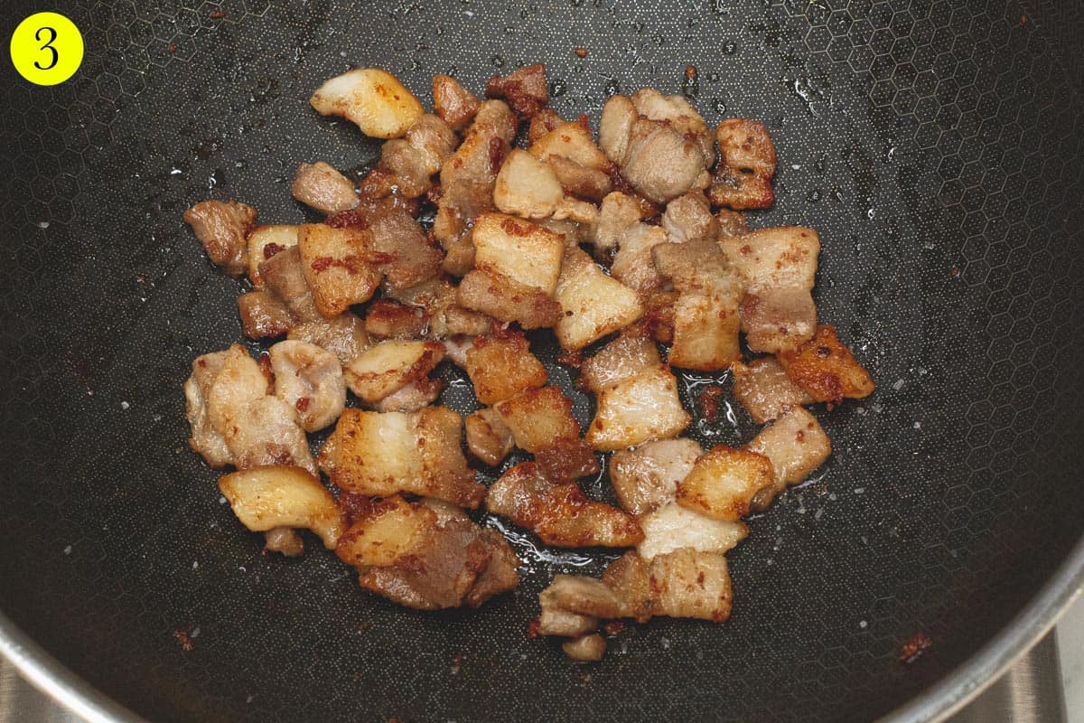 Browning the pork in a wok. 