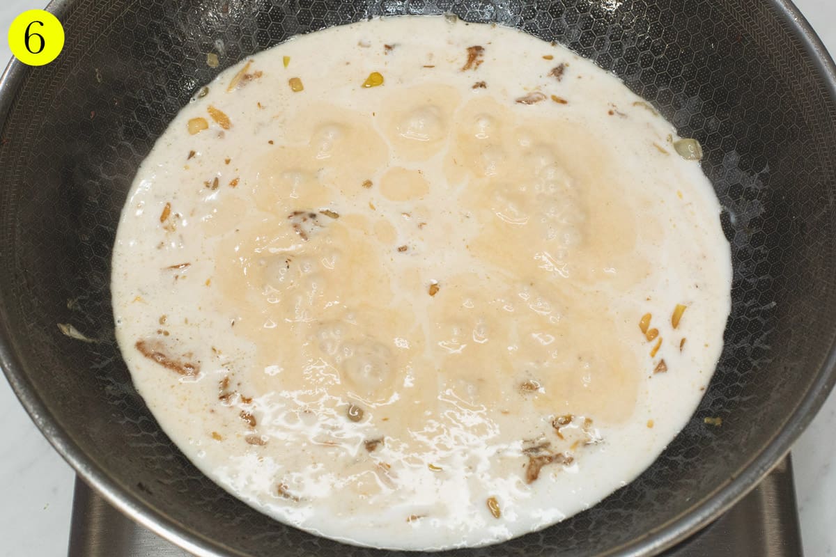 Simmering coconut mixture in a wok.