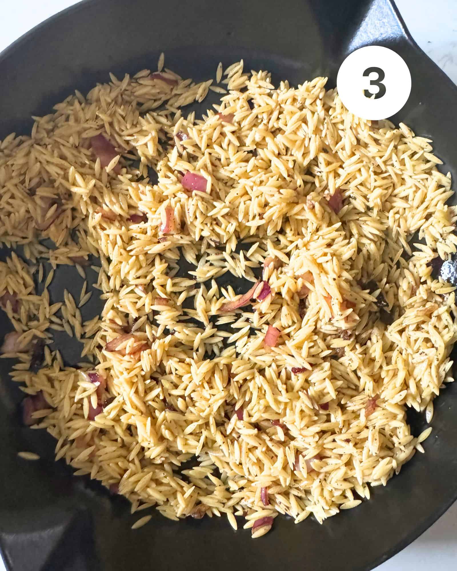 orzo toasted in a cast iron skillet with garlic and water.