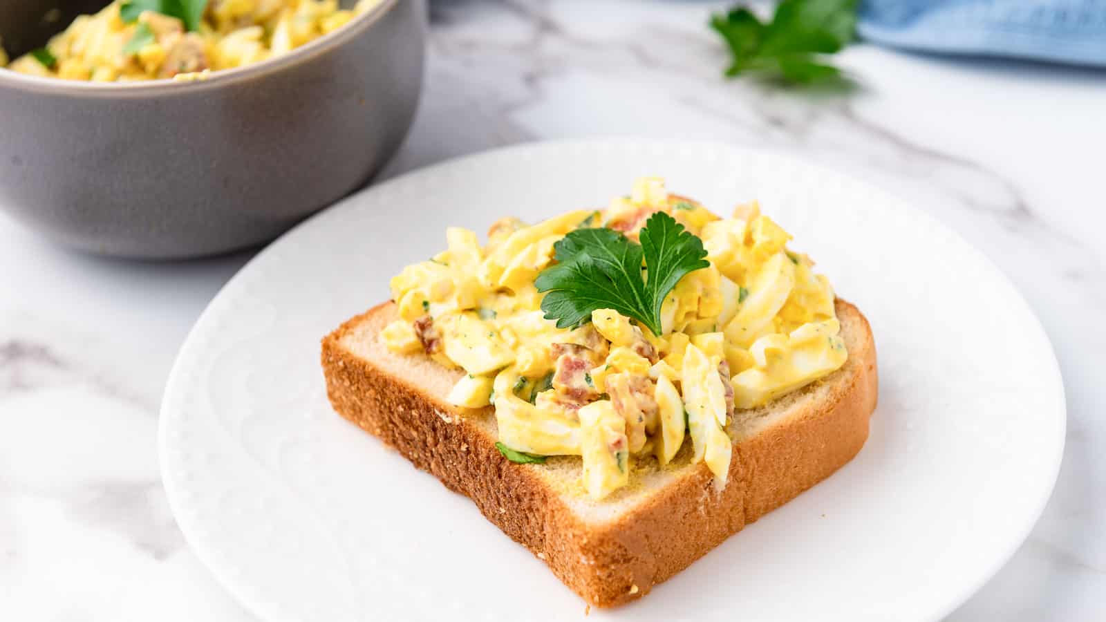 Egg salad on a piece of white bread.
