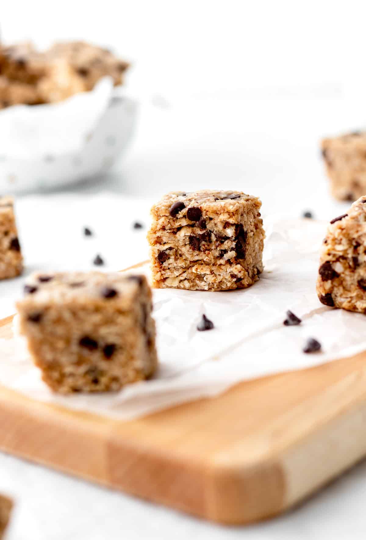 Chunks of the heavenly hunks cookie bars on a cutting board lined with parchment paper.