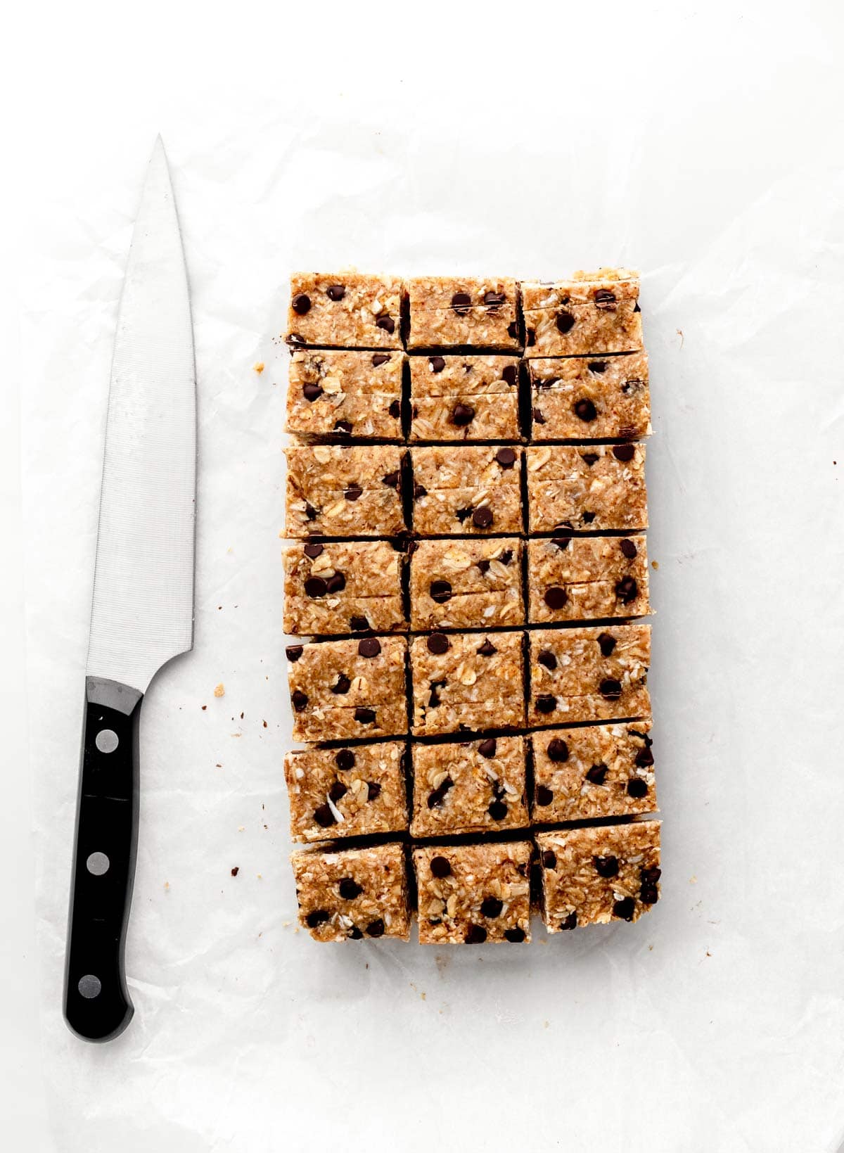 Cut heavenly hunks cookie bars on a cutting board next to a knife.