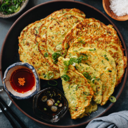 You cannot miss Chinese zucchini pancakes if you love a savory breakfast! Made with simple ingredients, these pancakes are crispy on the outside and tender on the inside. Served with a vinegar sauce and chili oil, you can easily finish half a dozen in one sitting! {Vegetarian}