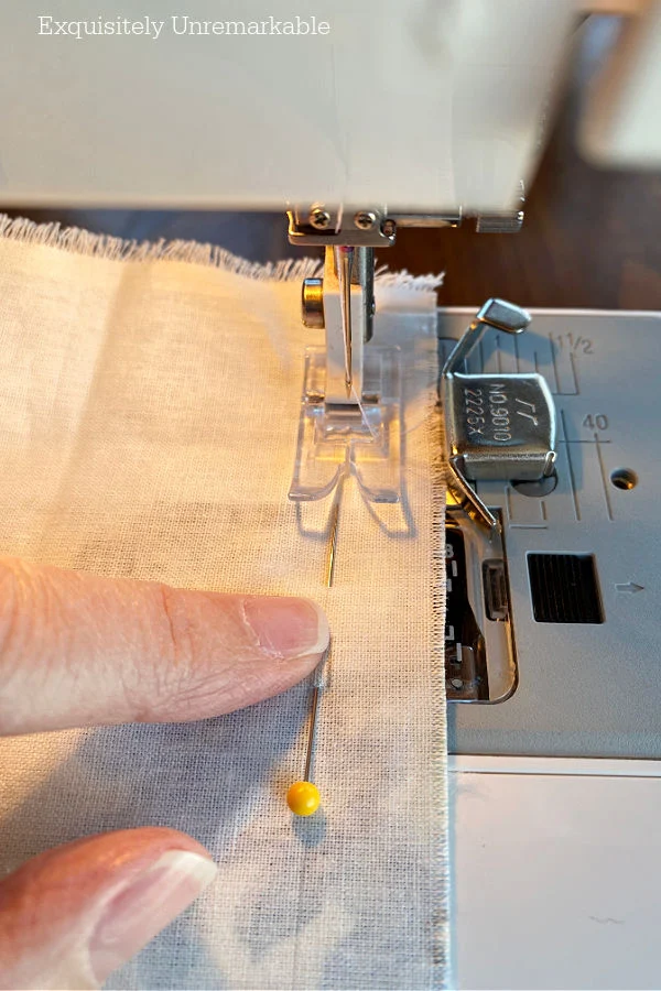 Pins is fabric while Stitching A Seam On A Sewing Machine
