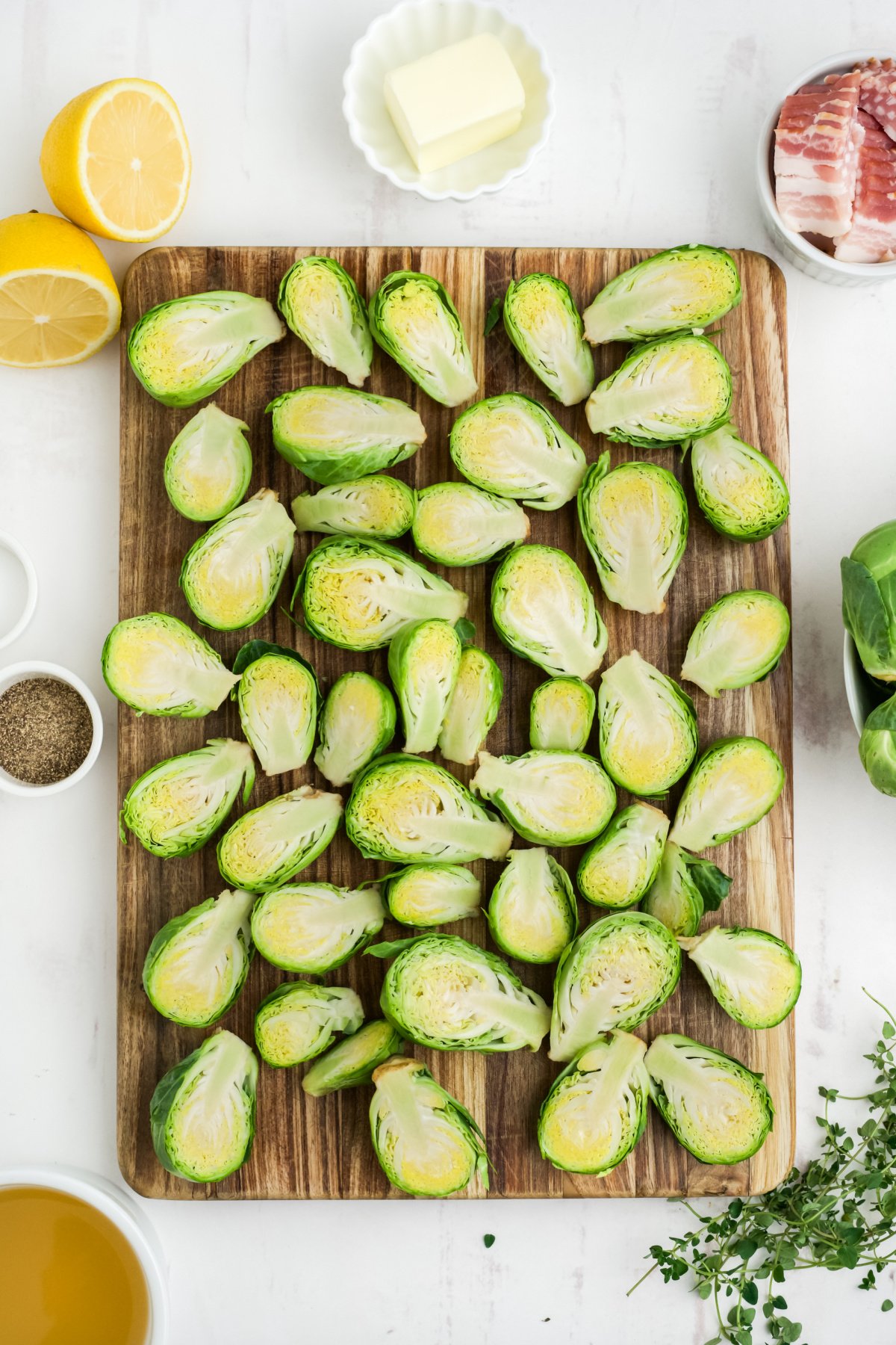 Brussels sprouts cut in half on a wooden cutting board.
