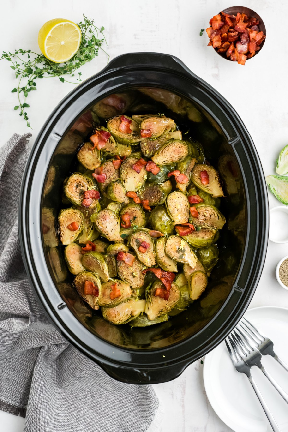 Bacon is sprinkled over the top of crockpot Brussels sprouts.
