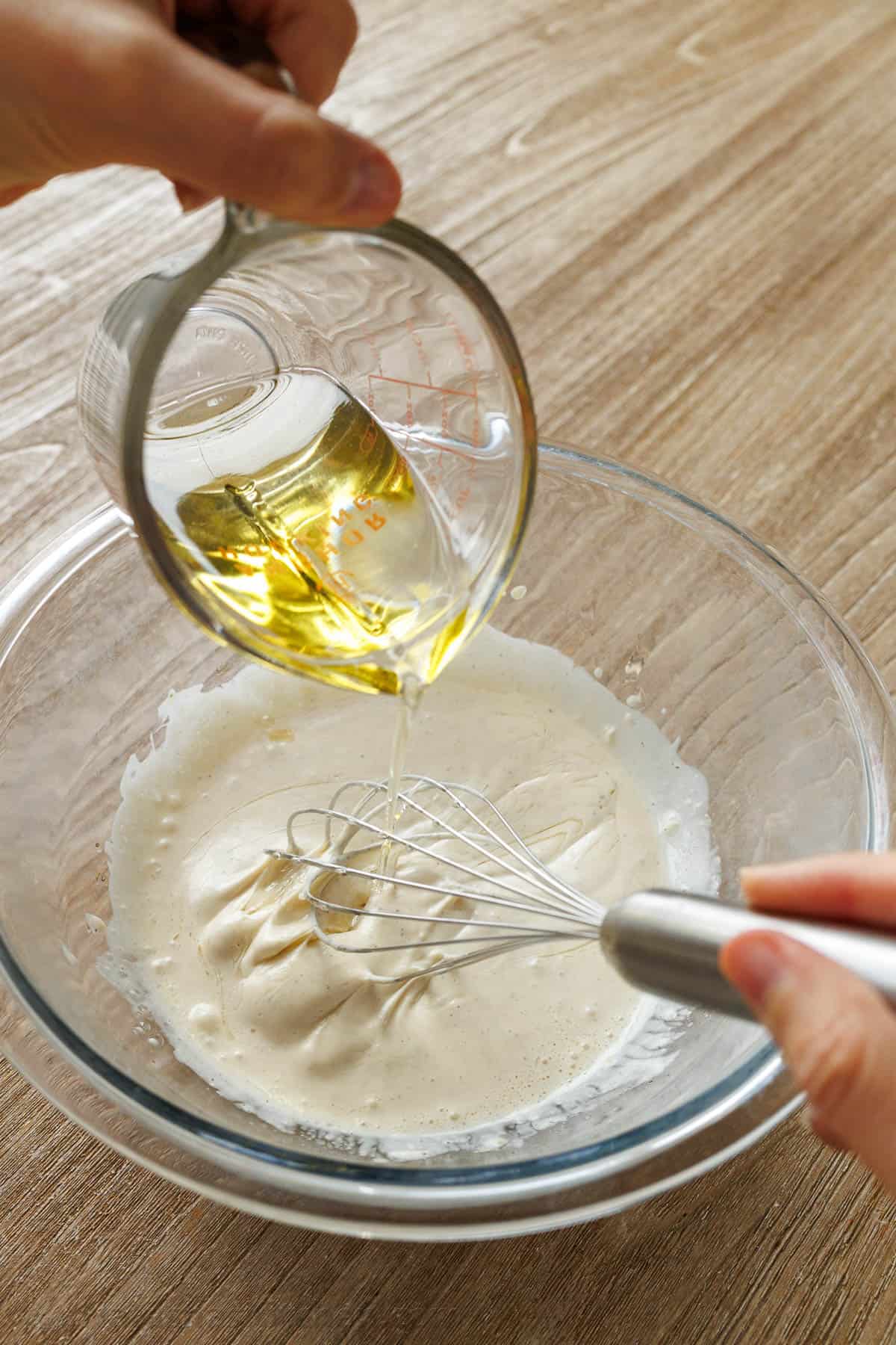 Lightly drizzle oil into the Caesar salad dressing and whisk together