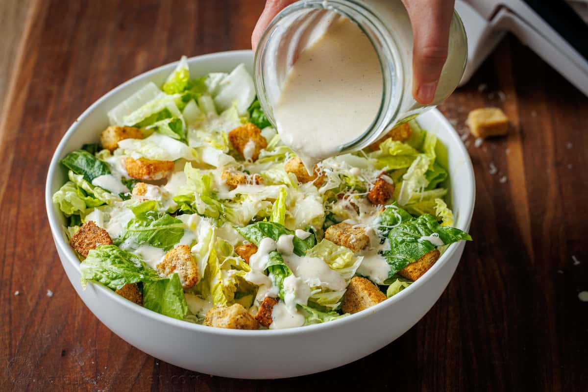Caesar salad with homemade Caesar dressing poured onto the romaine and croutons.