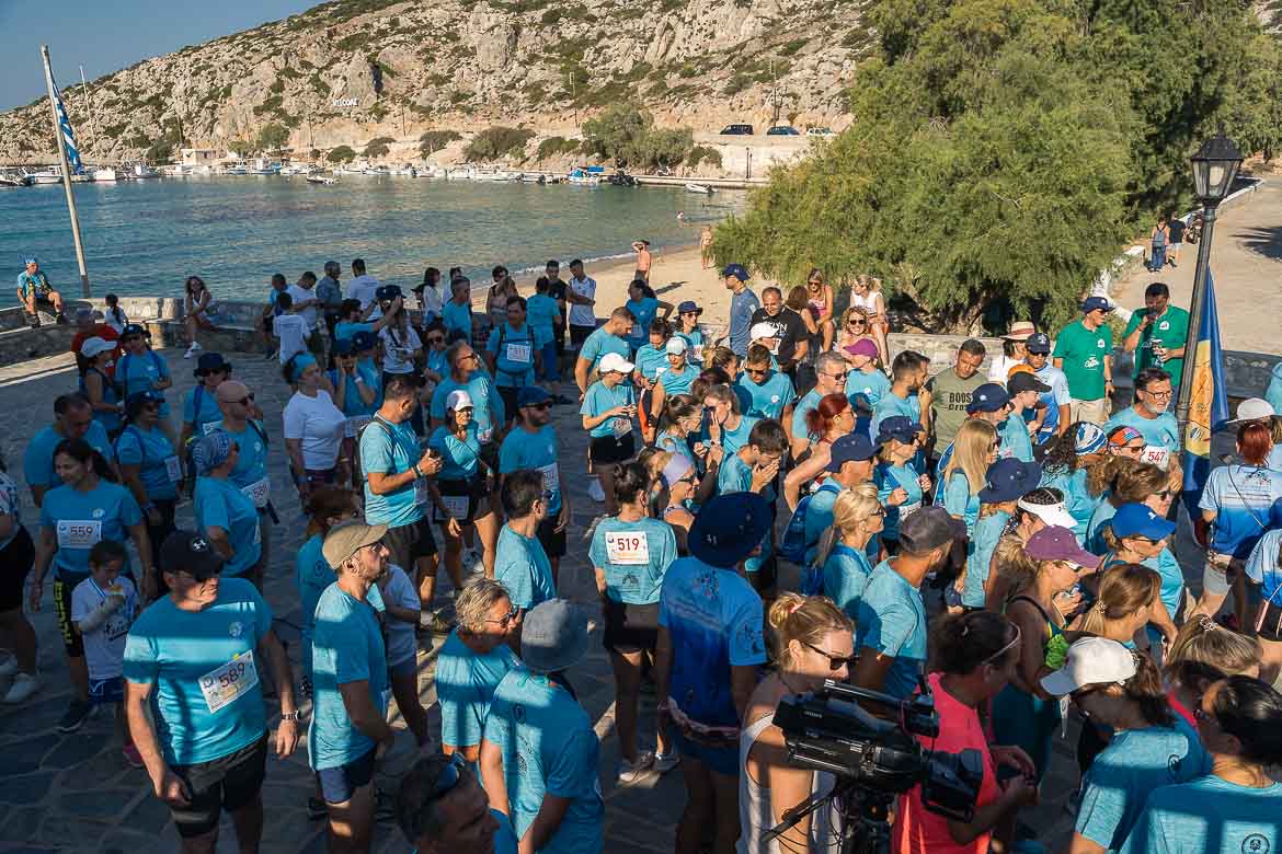 This image shows many people in sky-blue T-shirts waiting by the beach for the start of the running race. 