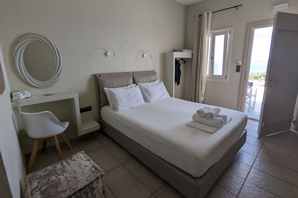 The double room in Villa Panorama. Apart from the double bed, the room has a door and a window, an open closet, a desk with a chair and a mirror.