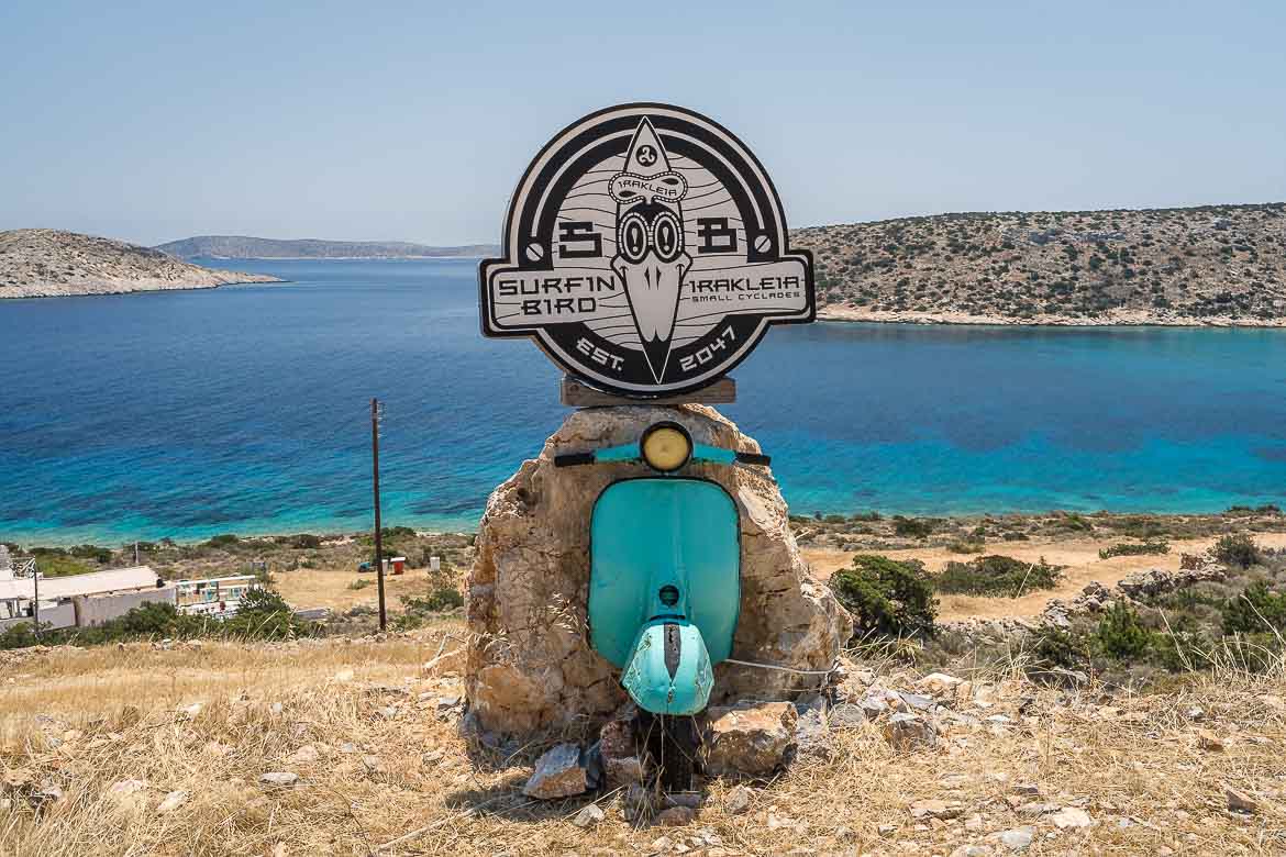 The cyan vespa's front part attached on a rock with the surfin bird logo on the top.