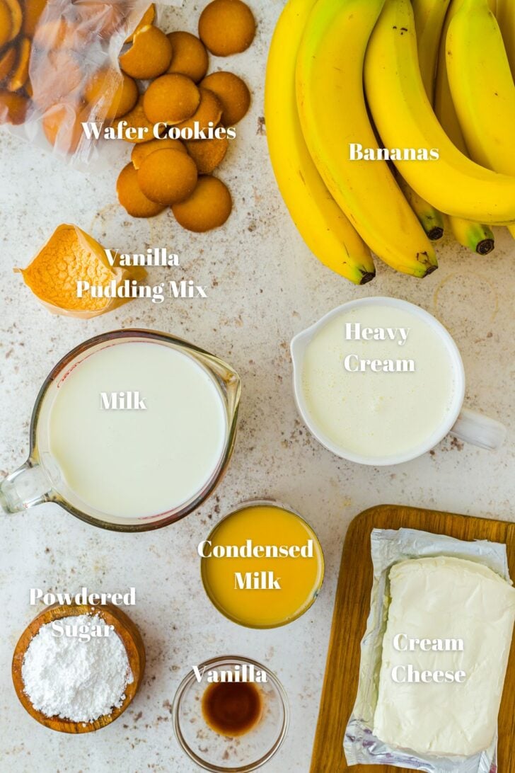 The ingredients to make banana pudding. Bananas, wafer cookies, vanilla pudding mix, heavy cream, milk, condensed milk, cream cheese, vanilla, powdered sugar.