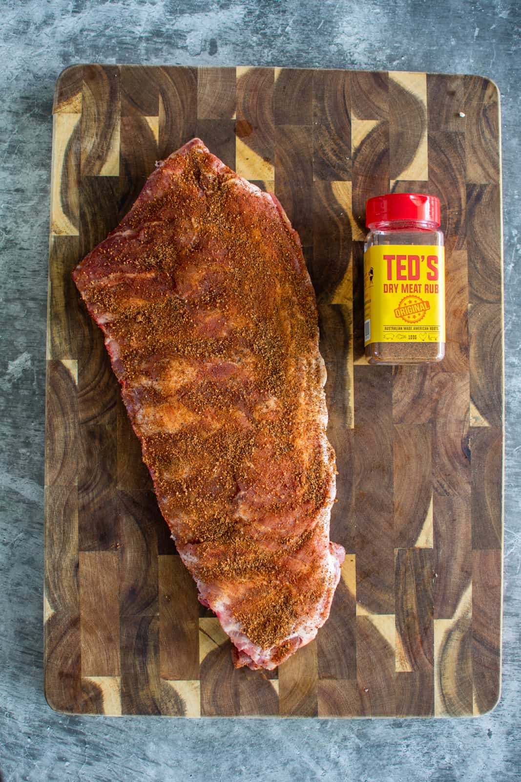 Pork spare ribs with teds dry rub on a chopping board 
