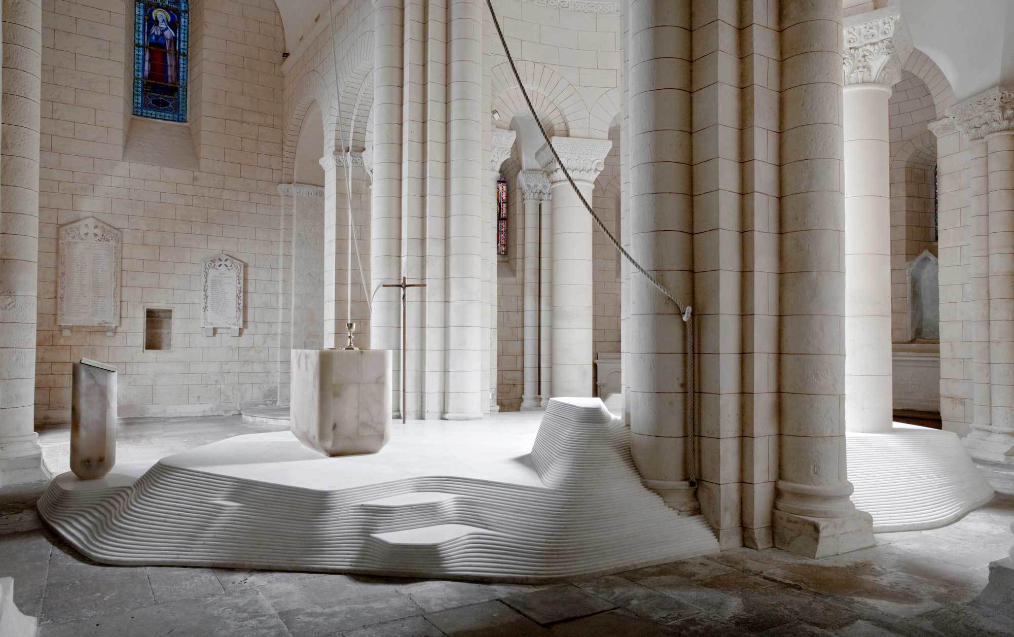 Im französischen Pilgerort Melle erzeugte Mathieu Lehanneur eine Komplizenschaft zwischen einem historischen Kirchenbau und seinen organischen, wellenartige Bodenskulpturen aus Marmor. Foto: Felipe Ribon