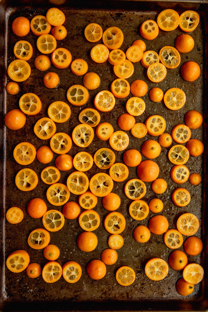 Sliced kumquats on a baking tray.