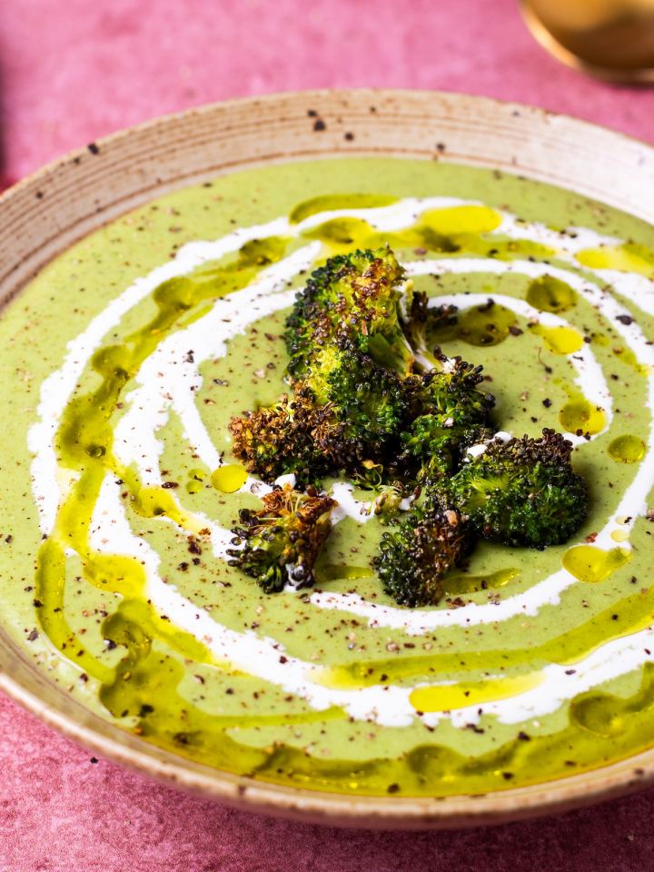 close up of crispy broccoli florets on a bowl of broccoli soup