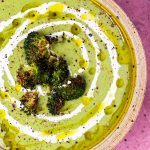 bowl with broccoli feta soup topped with roasted broccoli and swirled with olive oil and heavy cream
