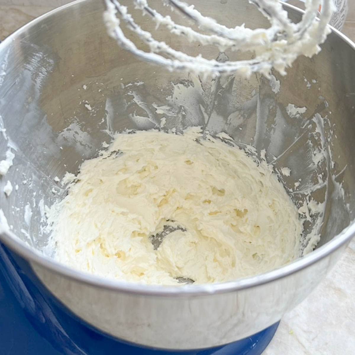 Whipped cream cheese in the mixer bowl, showing when it's smooth