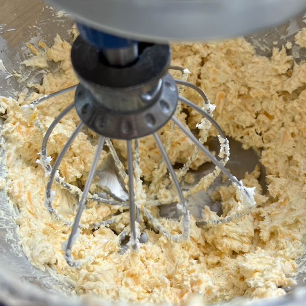 Mixer bowl with whisk inside showing when ingredients are mixed enough