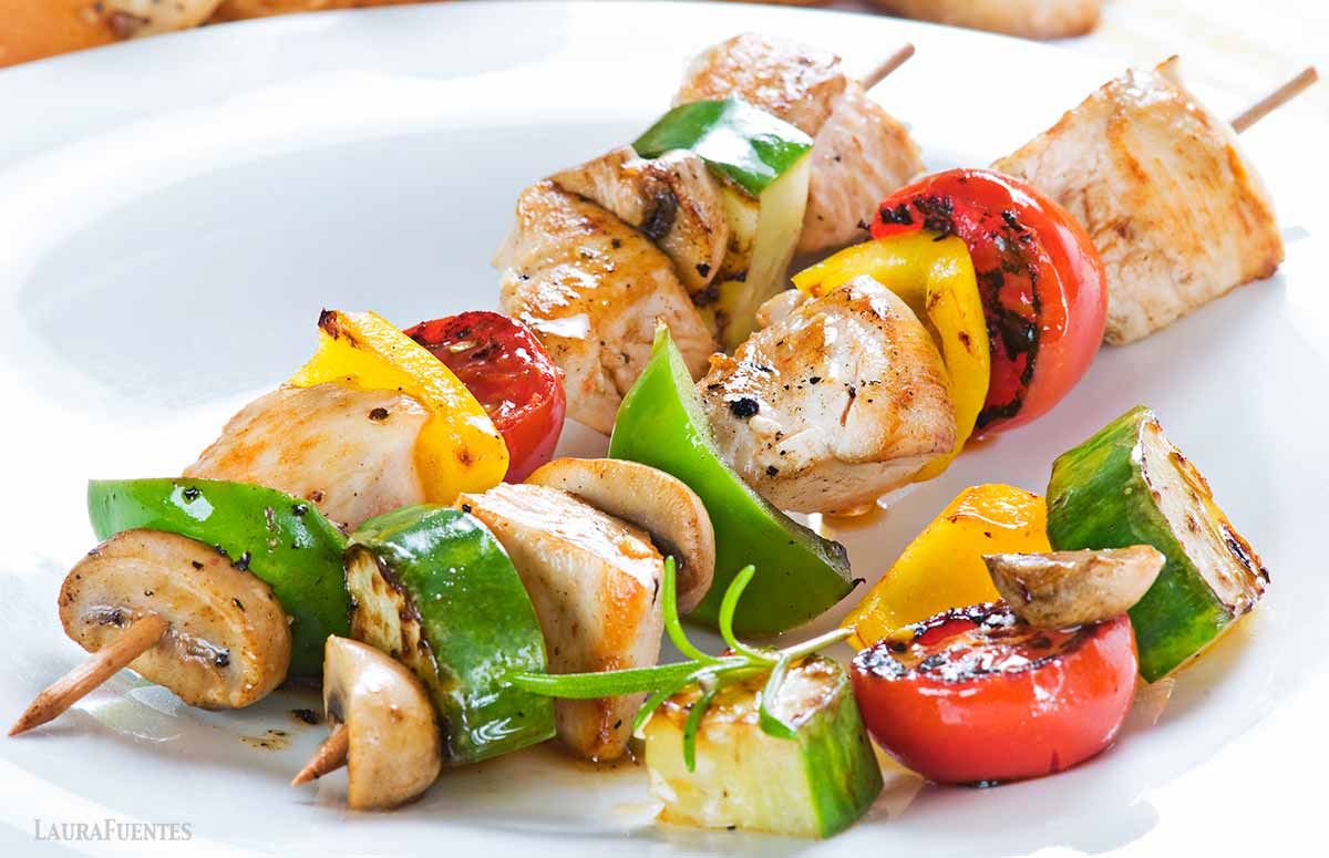 two chicken and vegetable kabobs on a plate