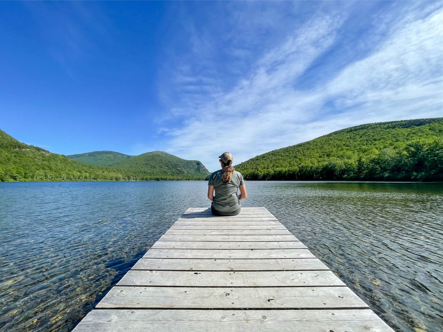 woman sitting on dock looking out on South Branch Pond in Baxter State Park