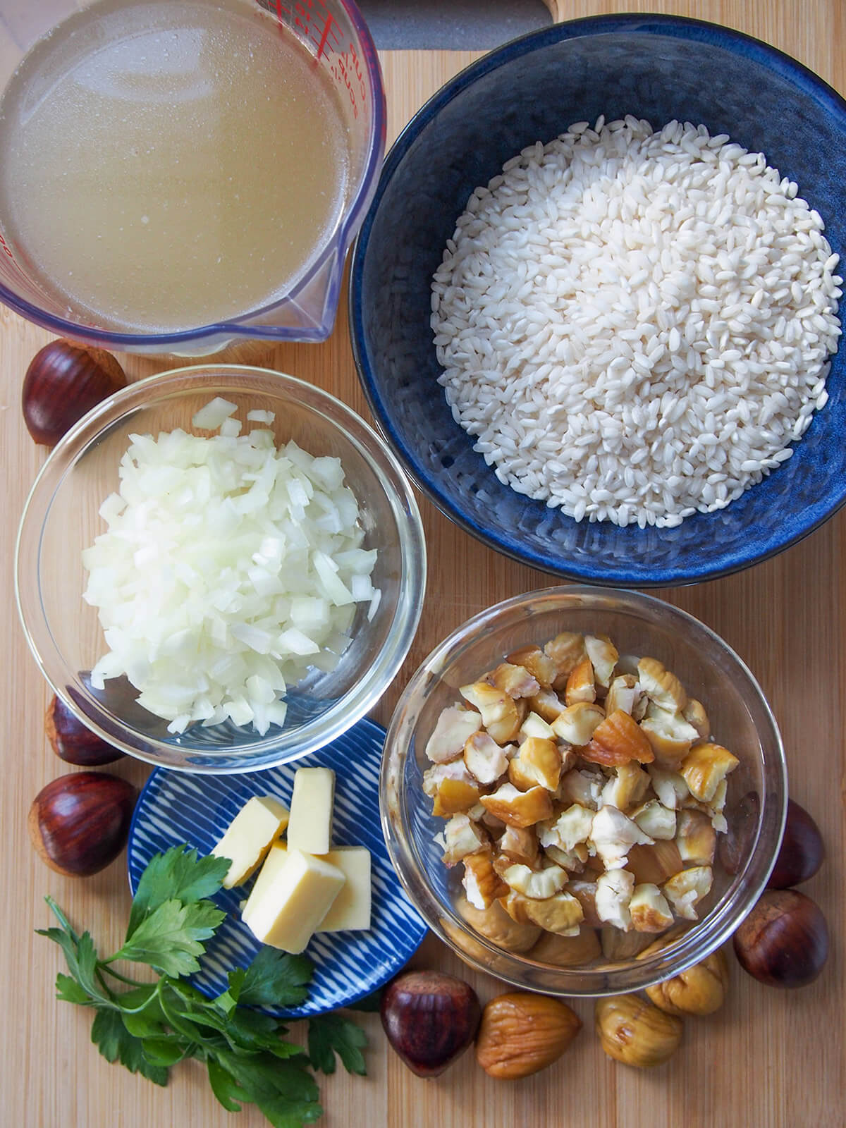 bowls with rice, chopped chestnuts, onion, butter and stock