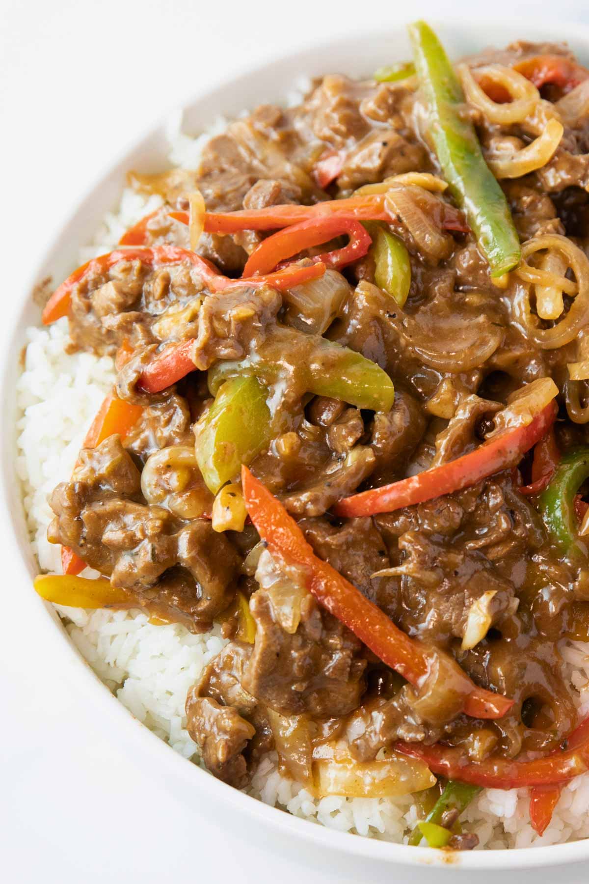 plate of pepper steak and onions over rice